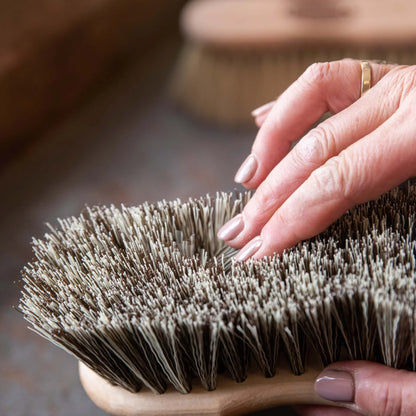 Borstiq Shaped Medium Brush on Equiflair: A hand touches grooming brush bristles