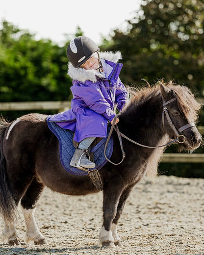 Child riding pony in EQUIDRY purple fleece coat, horseback riding.