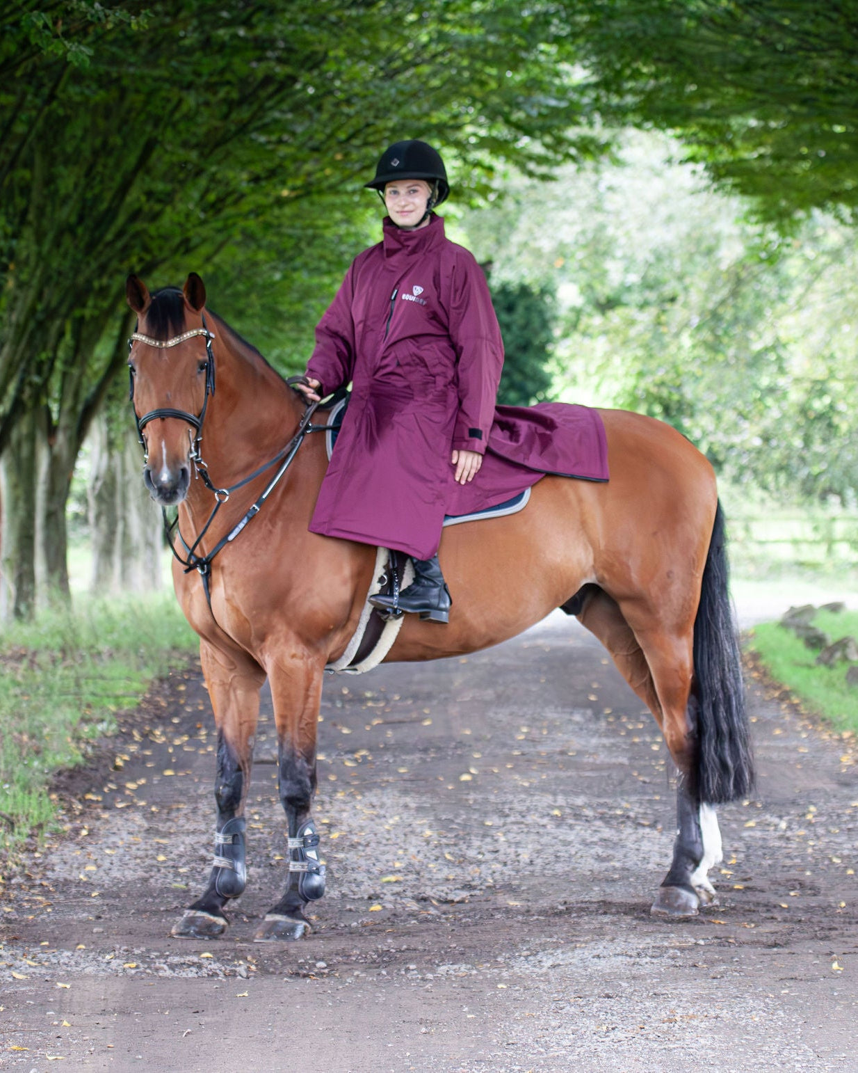 EQUIDRY women's thin fleece stowaway hood long waterproof horse riding coat in plum on horse