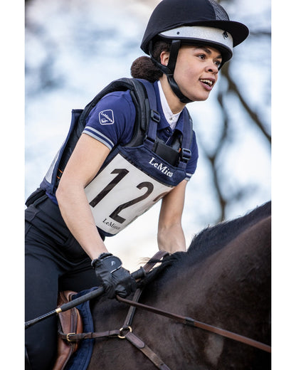 LeMieux Eventing Bib in Navy: Horse rider wearing competition bib number 12. Equestrian event accessory from Equiflair.