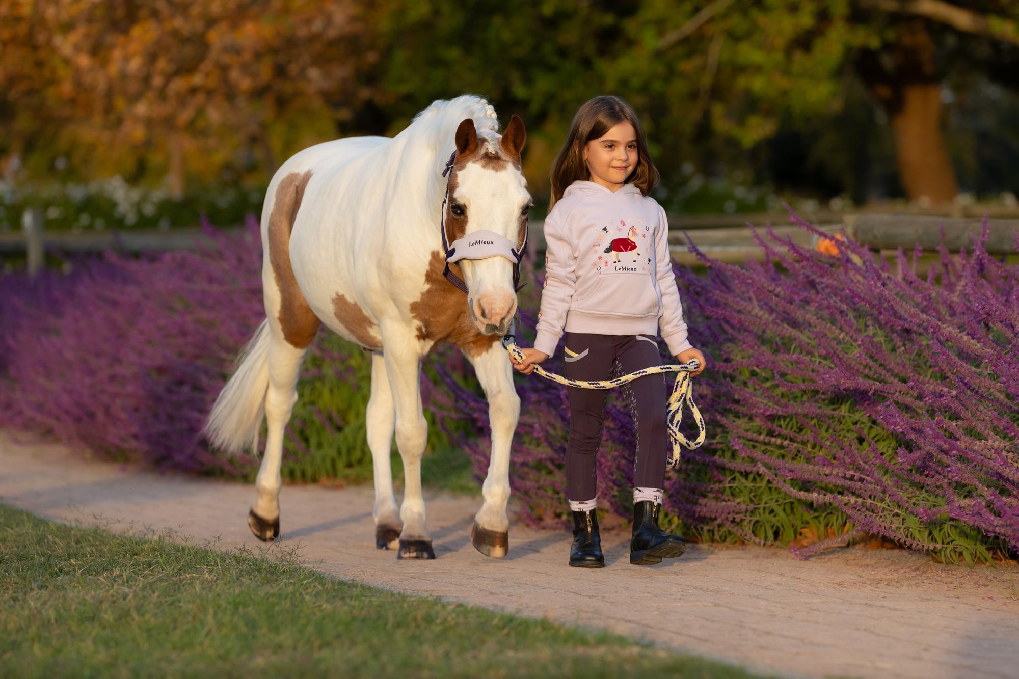 Girl with pony wearing LeMieux Juniper Headcollar. Equiflair store. Stylish, soft fleece horse headcollar for comfort.