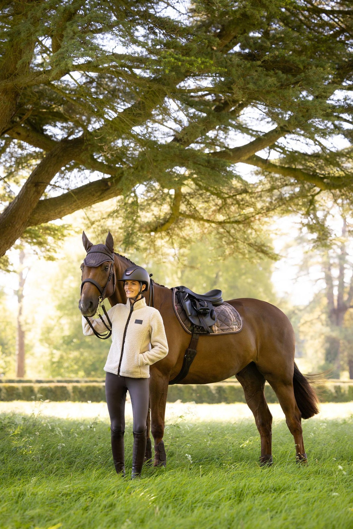 Equestrian rider with a brown horse wearing LeMieux Heritage Check Jump Square in Cocoa.
