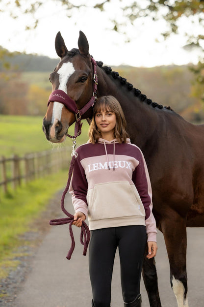 Woman in LeMieux Wild Rose colour block hoodie with a horse. Equestrian fashion.