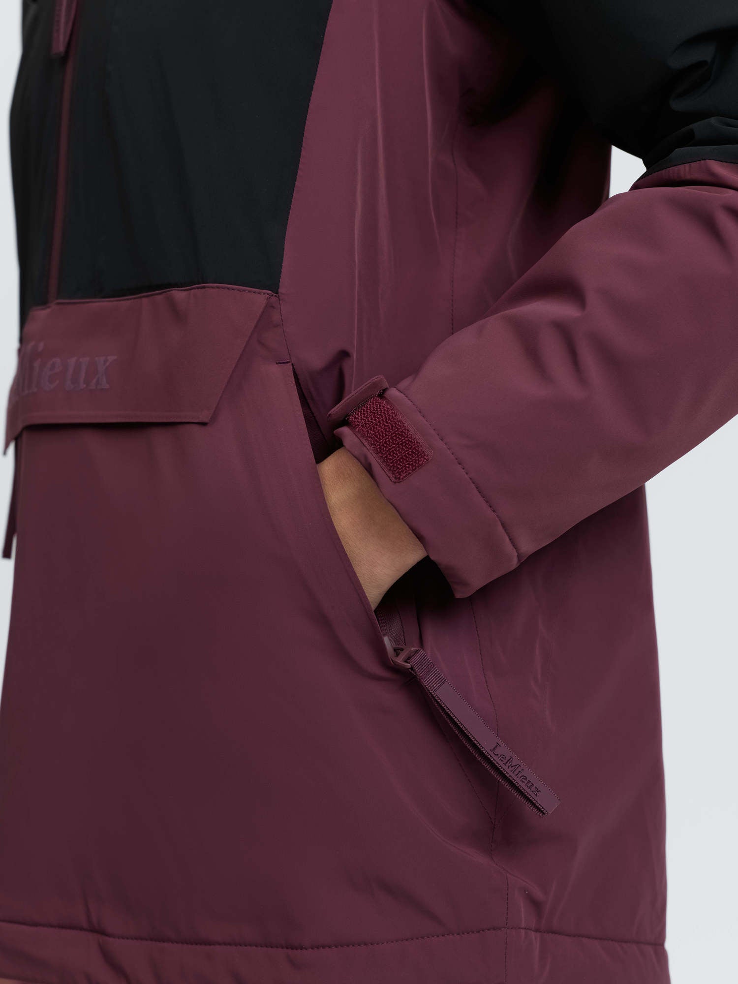 LeMieux Phoebe Half Zip Waterproof Anorak in Black/Bramble: Kangaroo pocket detail, taped seams, LeMieux logo tag.