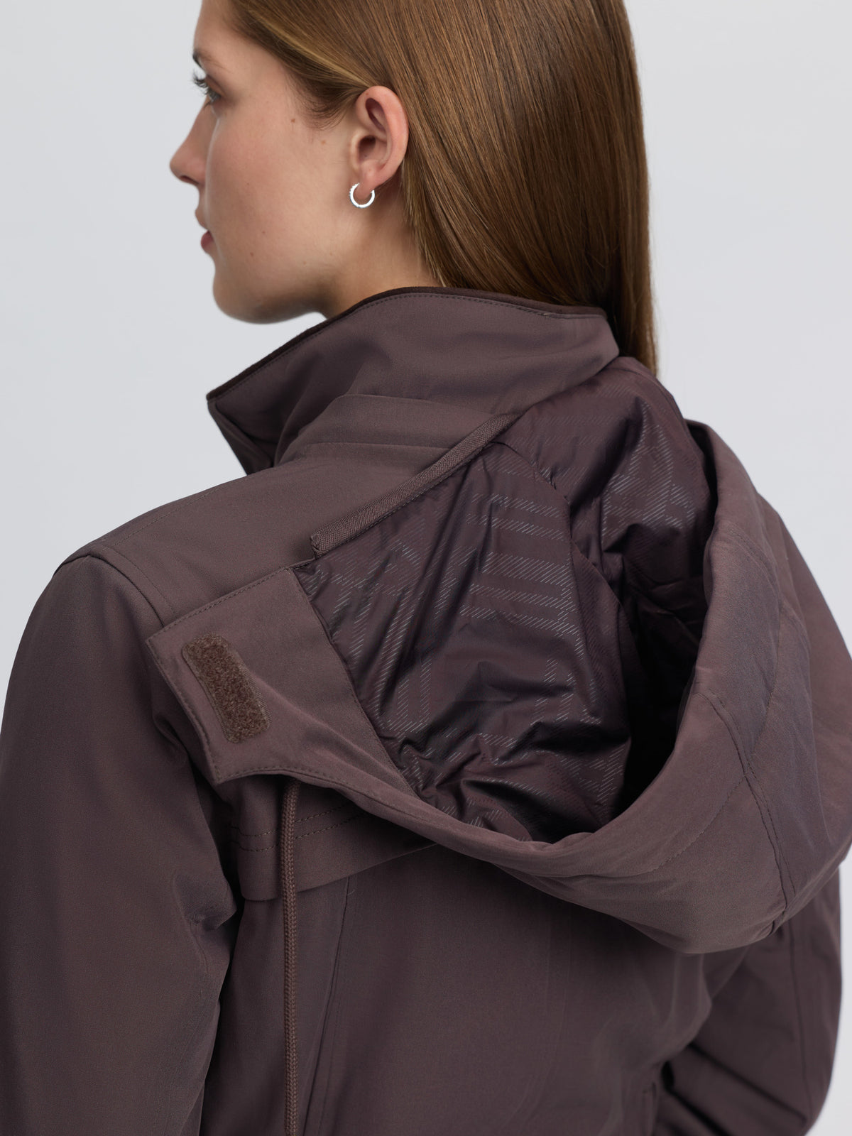 Woman wearing a LeMieux Heritage Beatrice waterproof coat in cocoa, back view.