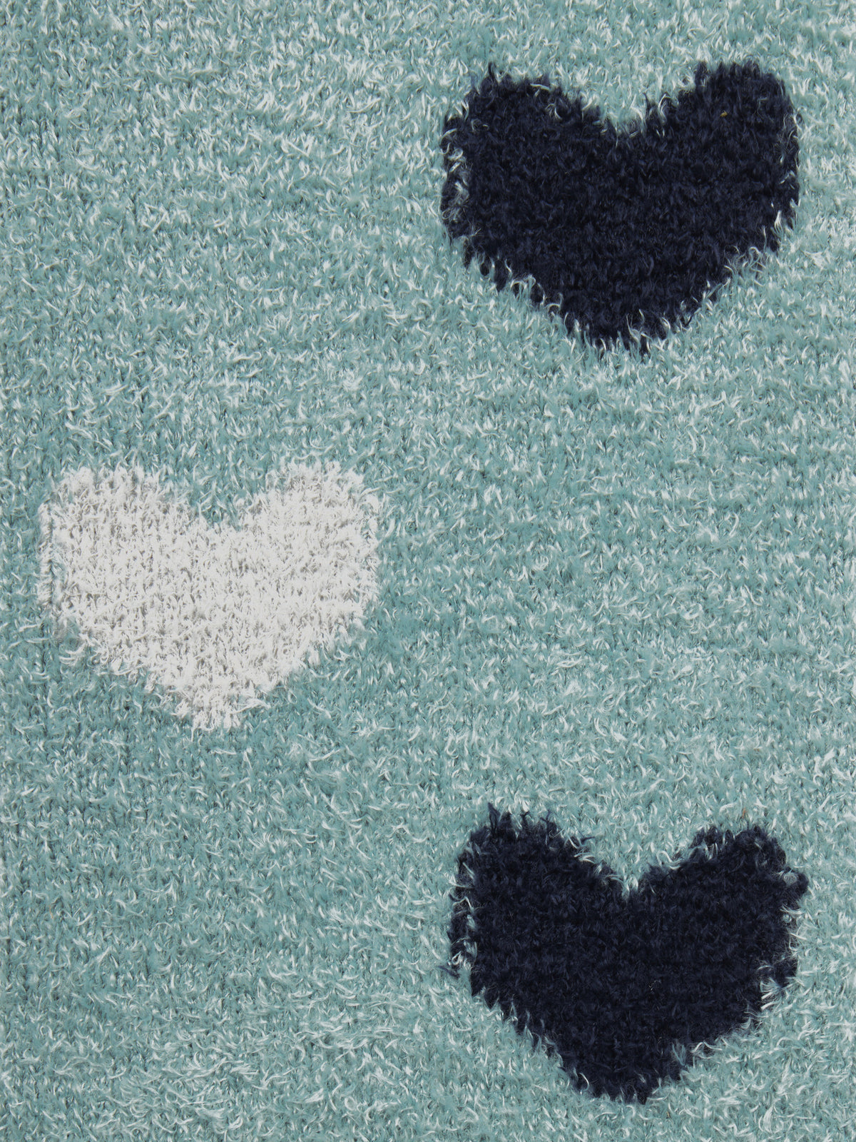 Close-up of LeMieux Heart Fluffies Aloe socks featuring teal fabric with navy and white heart patterns