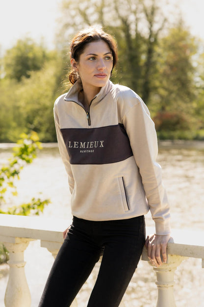 LeMieux Heritage Quarter Zip Sweat in Stone worn by a woman outdoors by a railing.