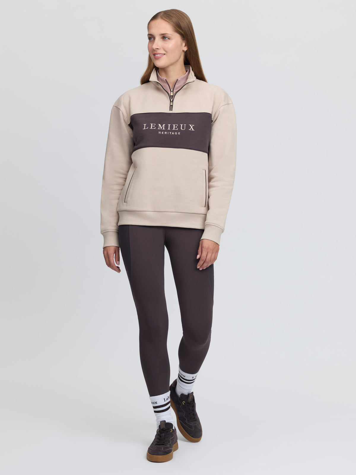 LeMieux Heritage Quarter Zip Sweat in Stone worn by a woman, featuring contrasting panel and logo.