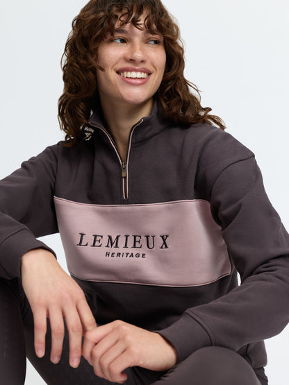 Woman wearing LeMieux Heritage cocoa brown quarter zip sweatshirt with dusty pink chest panel and diamond quilting.