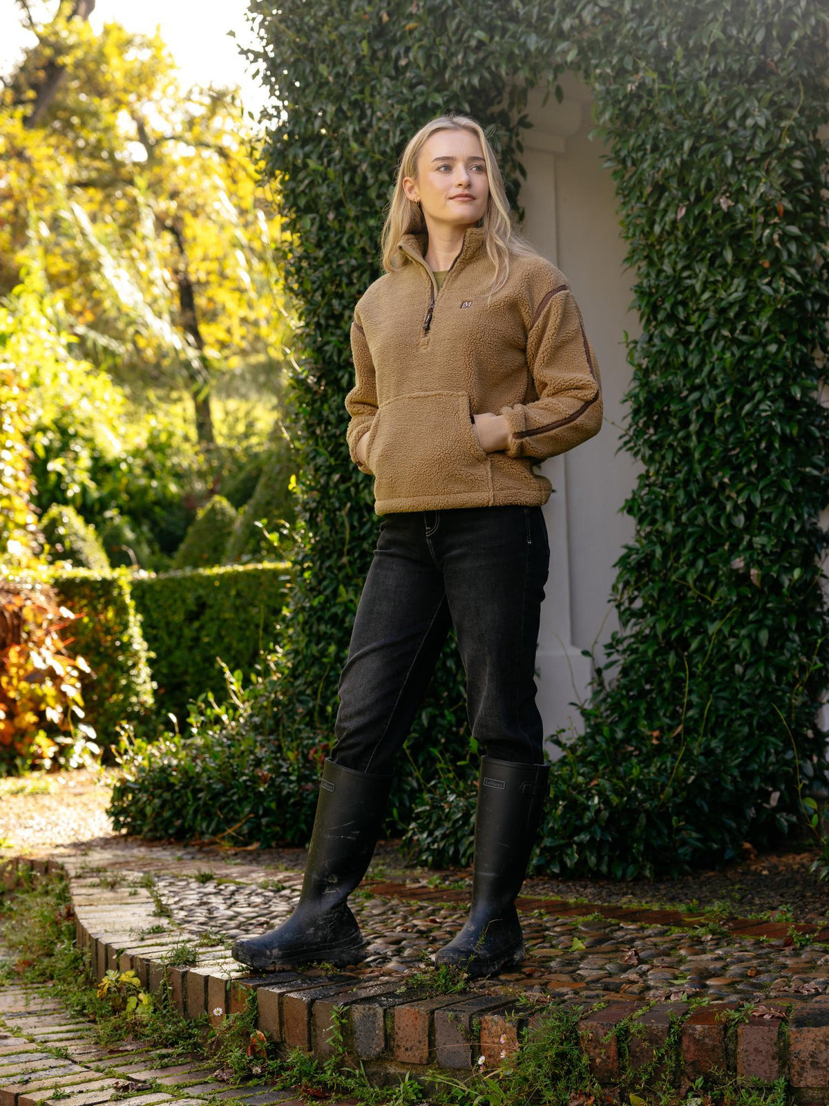 LeMieux Avery Teddy Quarter Zip Fleece in Caramel worn by a woman outdoors.