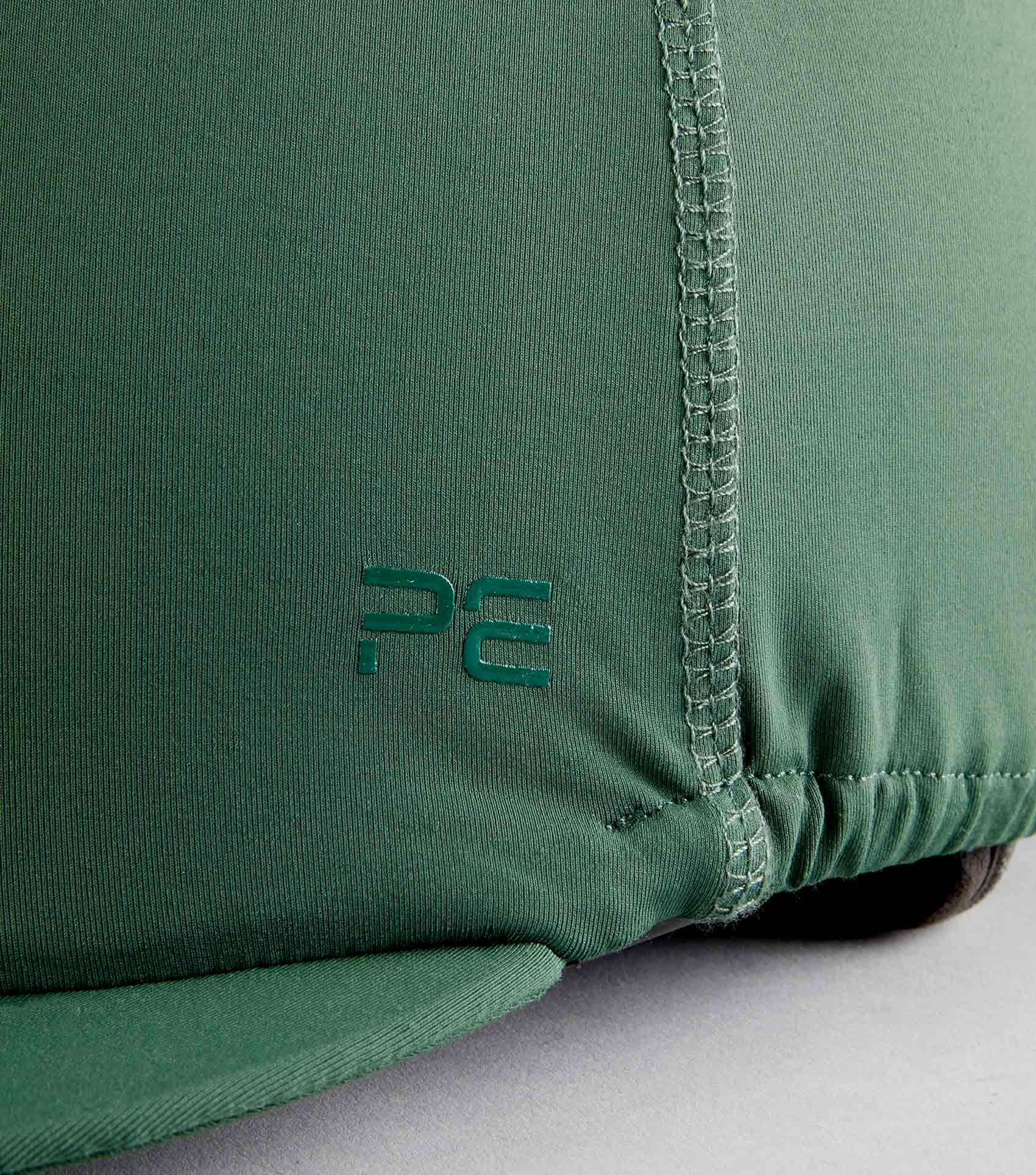 PREMIER EQUINE Jersey Hat Silk with Faux Fur Pom Pom - Green. Stylish skull cap cover by Equiflair.