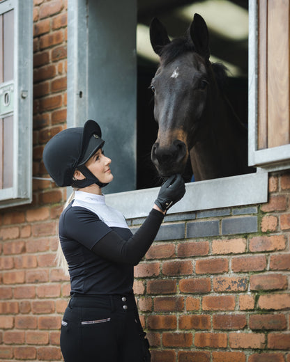Woman and Horse at Stable: Riding Helmet, Equestrian, Horse, Care, Love.
