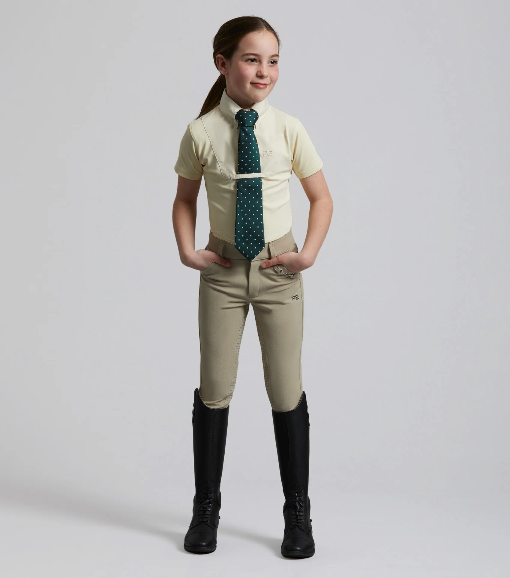 Girl in Premier Equine Luciana Show Shirt: Equestrian riding apparel, short sleeve, competition attire, youth riding clothes.