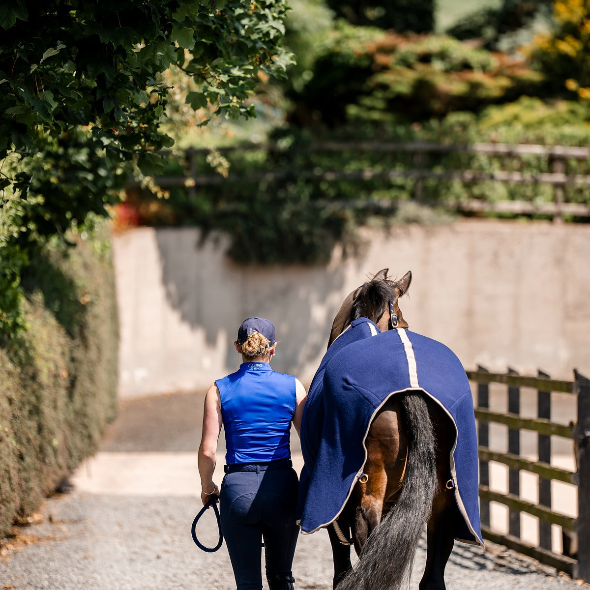 Woman leading horse in Equiflair CAMEO ELEVATE SHOW RUG NAVY. Equestrian apparel, horse blanket. #Equiflair #HorseRug