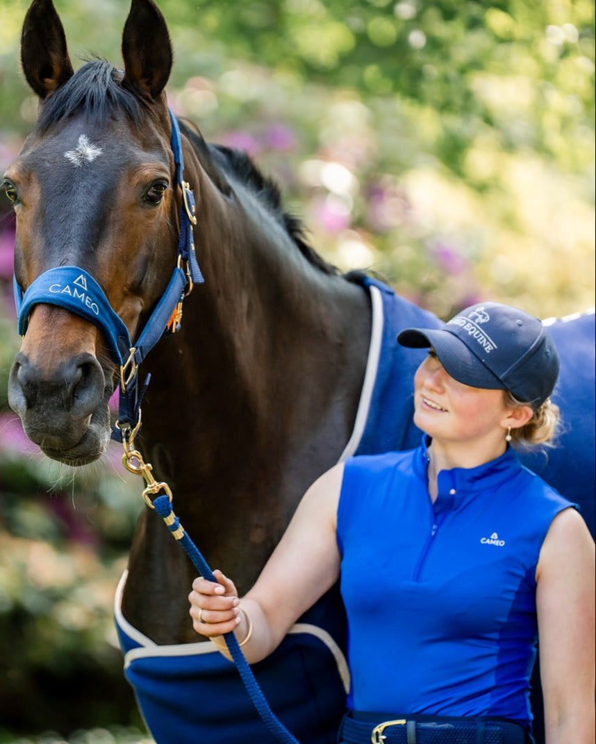 Woman with horse wearing CAMEO Equestrian navy baseball cap. Equestrian lifestyle photo.