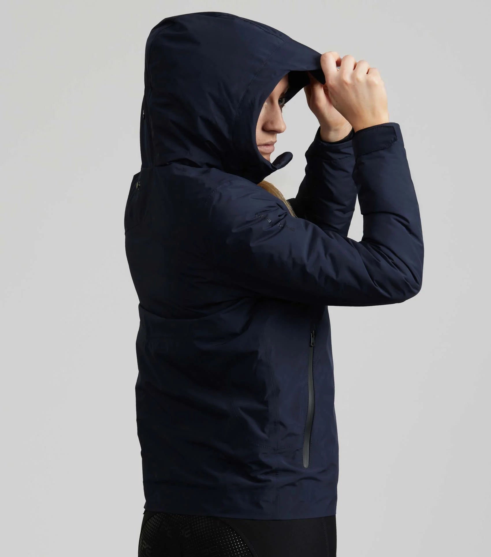 PREMIER EQUINE MOTET French Navy Waterproof Ladies Equestrian Jacket. Close-up side view of jacket hood up.