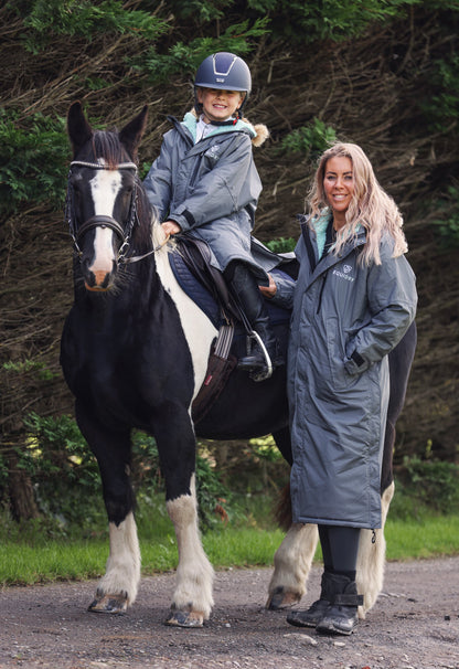 EQUIDRY women's long waterproof horse riding coat in Charcoal/Jade modelled by mother and daughter with horse 