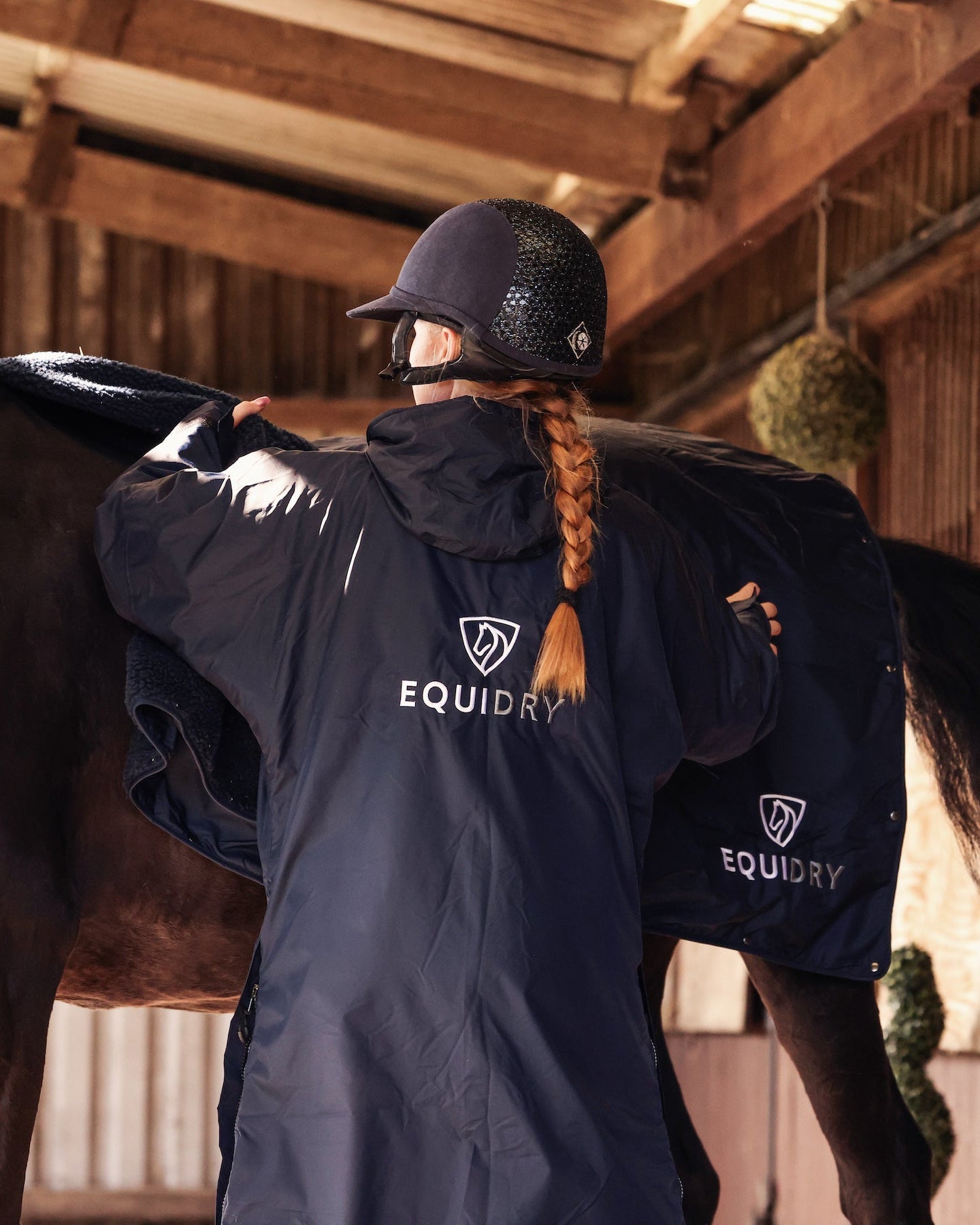EQUIDRY women's long waterproof horse riding coat in Dark Navy/Navy showing horse with matching equiblanket