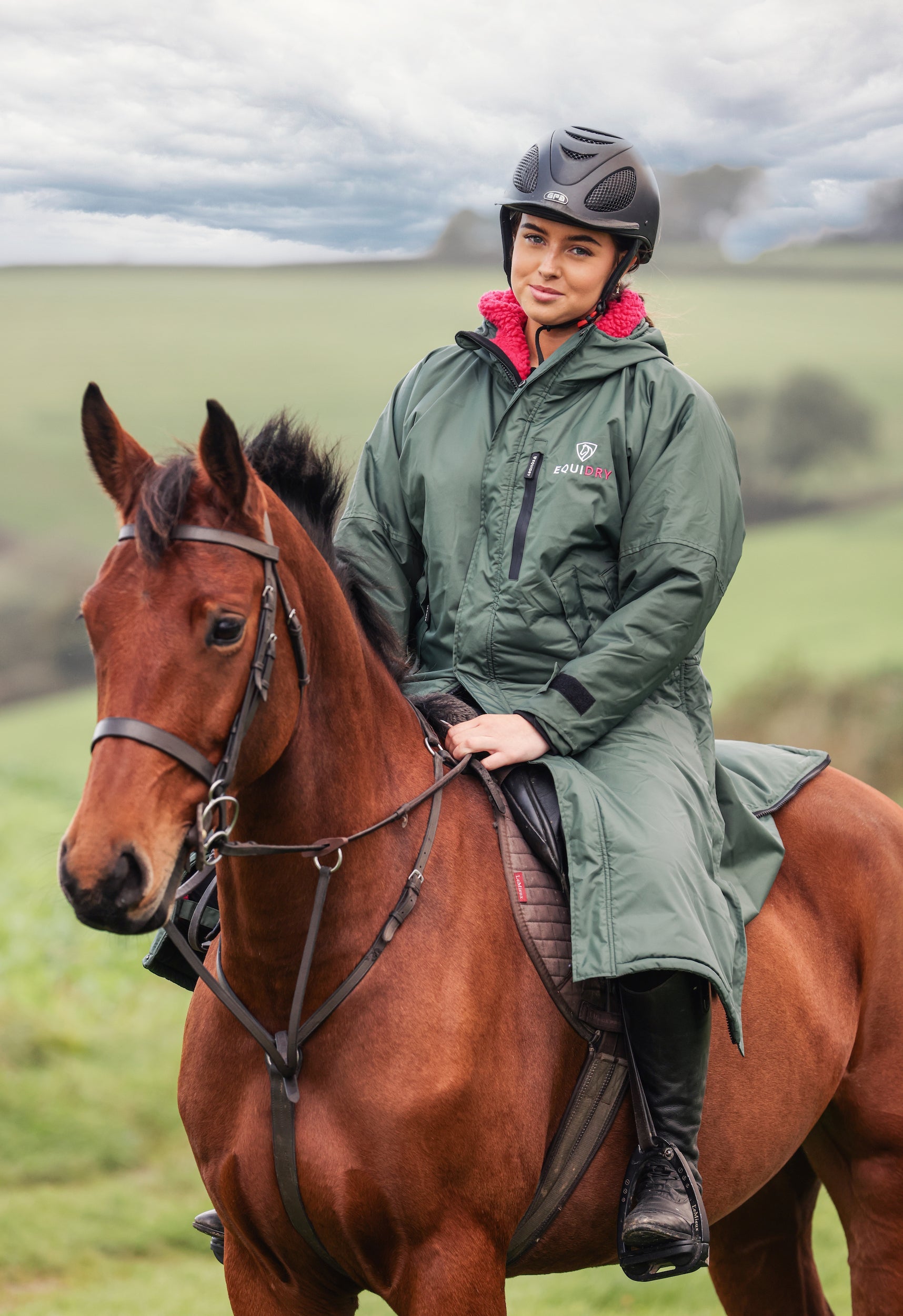 EQUIDRY women's waterproof horse riding coat (black forest green/peacock pink) worn on horseback.