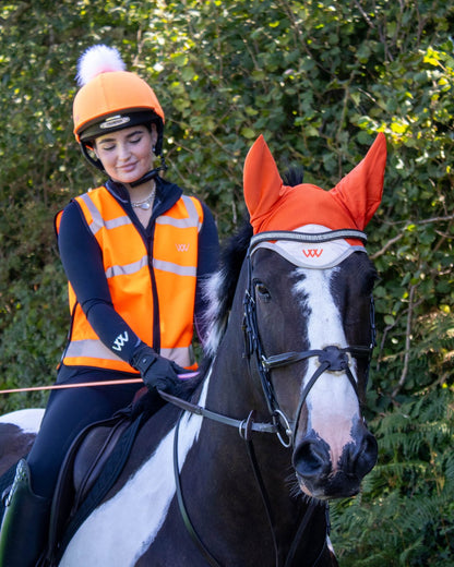 Woof Wear Hi Vis Riding Vest: Rider in High Visibility Orange Equestrian Safety Vest on Horseback.