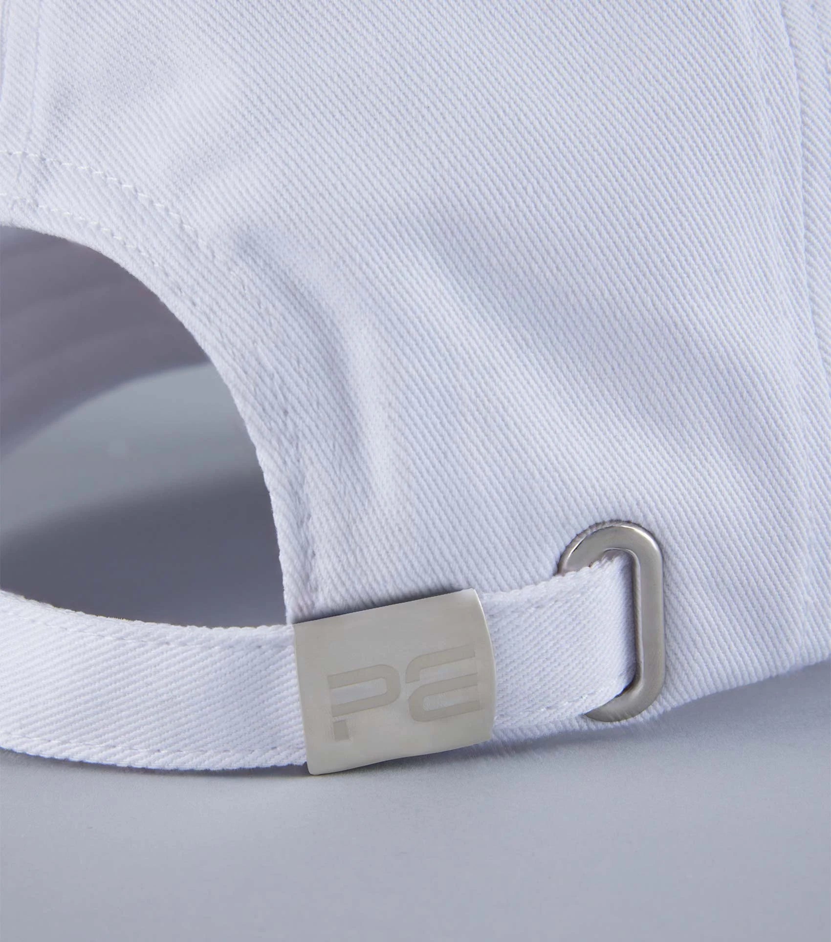 Premier Equine White Baseball Cap: Adjustable, Embroidered Design. Stylish Sportswear Accessory. Close up shot of clasp and band.