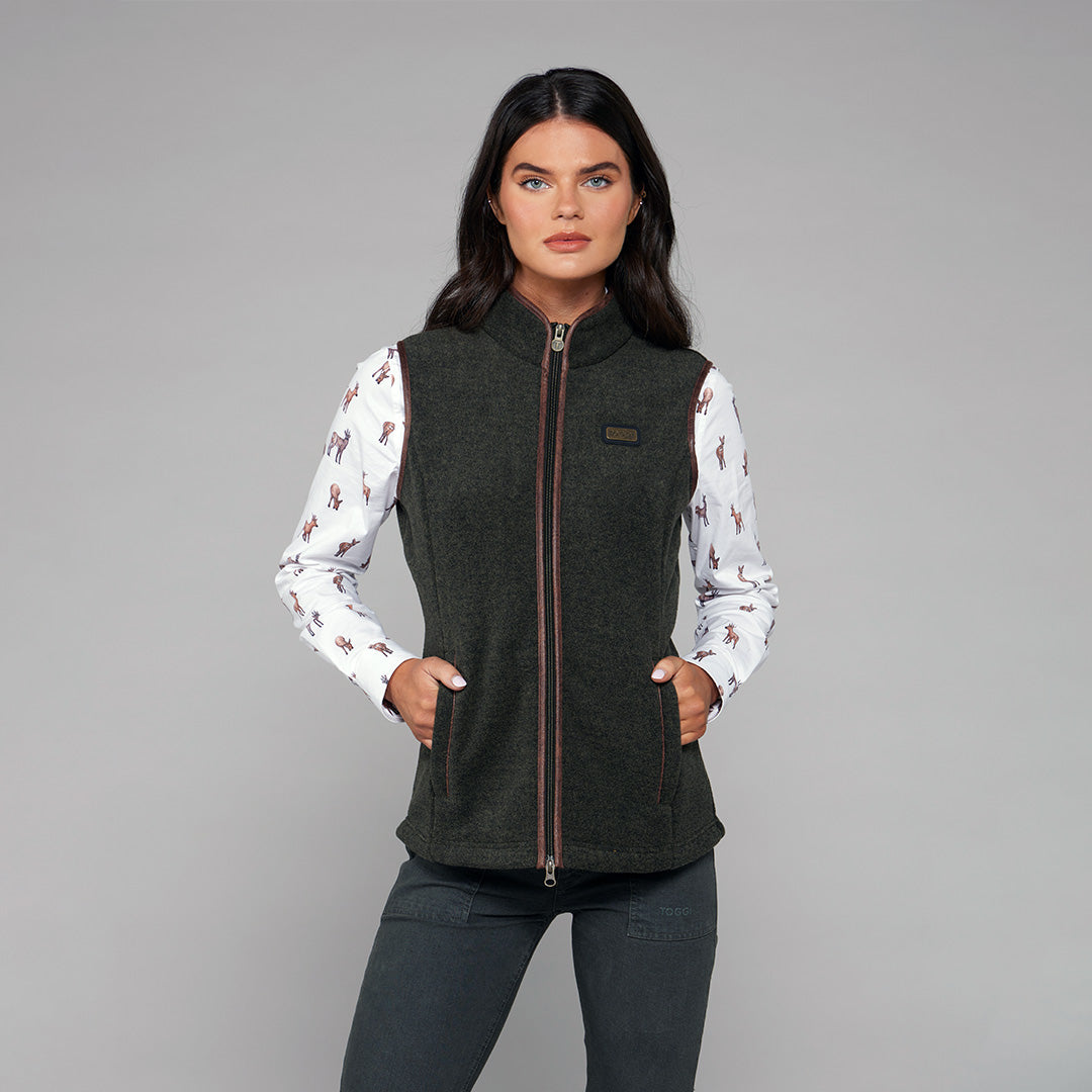TOGGI REGENT Women's dark green fleece gilet worn with a deer print shirt.