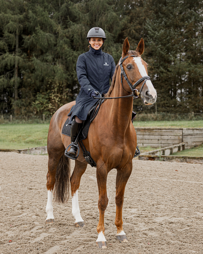 EQUIDRY Women's Bronte Riding Coat: Woman on Horseback in Navy Waterproof Equestrian Apparel