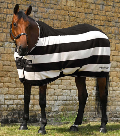 Horse wearing a black and white striped Premier Equine fleece rug from Equiflair. Comfortable and stylish horse blanket.