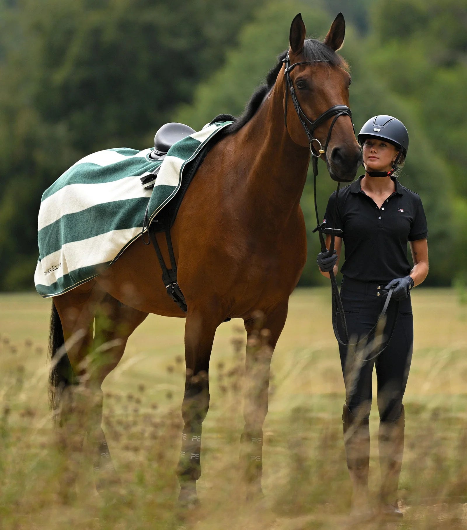 PREMIER EQUINE VELLUS HORSE FLEECE EXERCISE RUG GREEN/WHITE. Horse and Rider in riding gear.