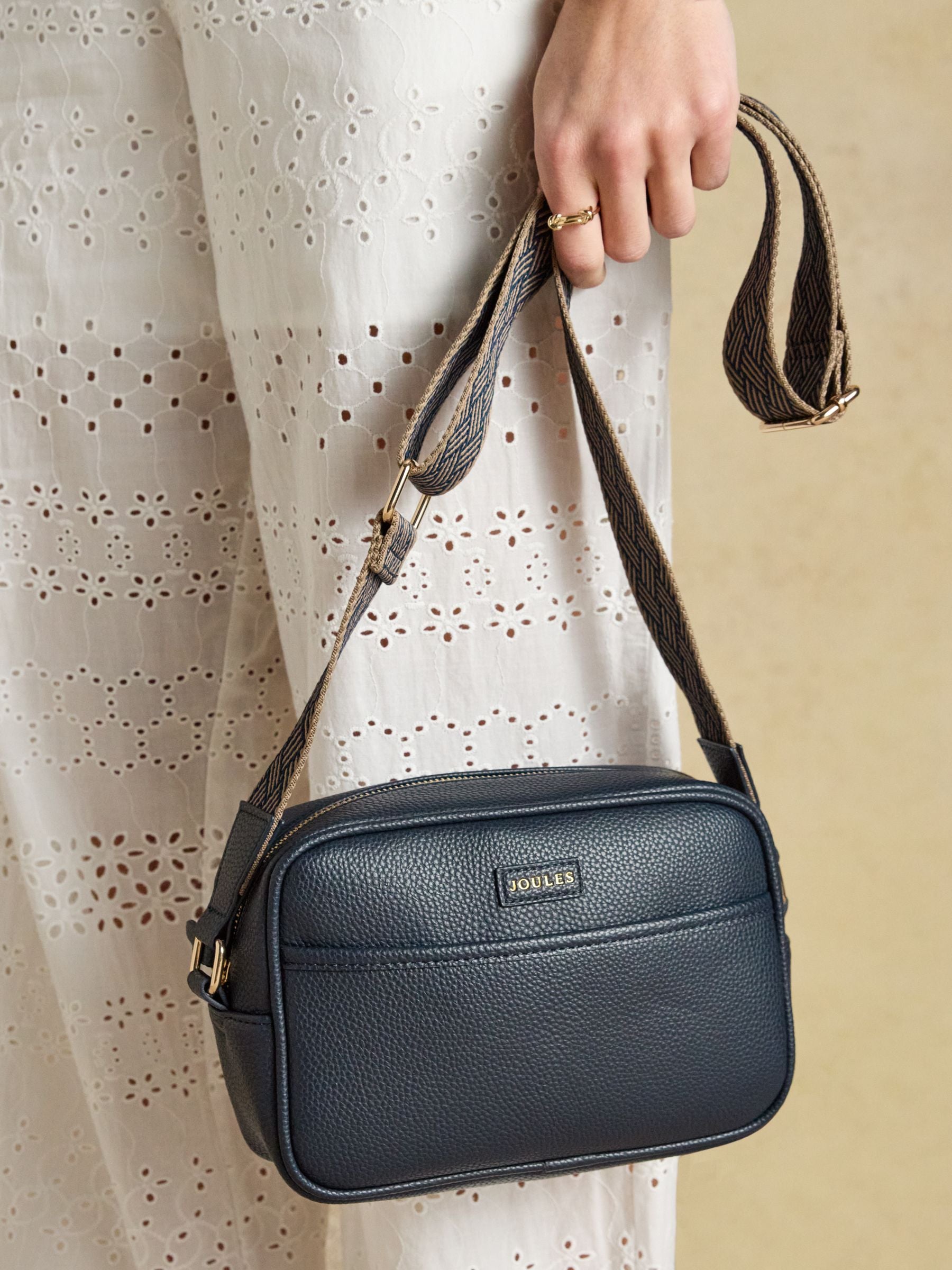 Joules navy cross body bag with adjustable strap, faux leather, and zip closure.