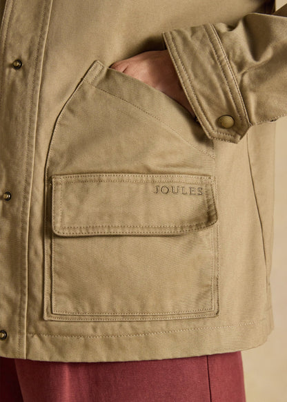 Joules women's tan barn jacket featuring a dual-entry pocket with embroidered logo detail.