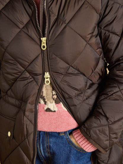 Joules Women's Brown Showerproof Quilted Coat with Pink Knit Sweater and Blue Jeans | Close-up