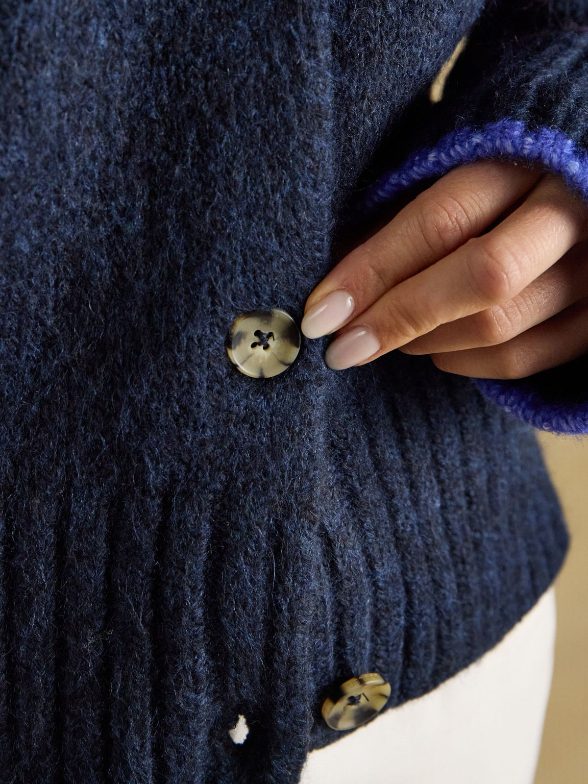 Close-up of women's Joules navy wool blend cardigan showing mock horn button detail and knit texture.