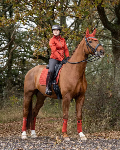 Woman riding horse with LEMIEUX Loire Classic Dressage Square SIENNA saddle pad. Horse riding equipment.