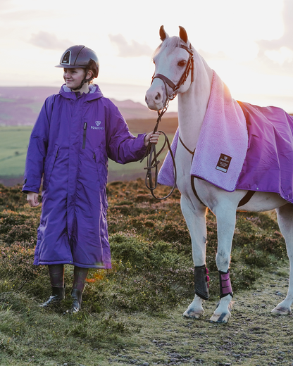 EQUIDRY women's long waterproof horse riding coat in deep purple/lilac with horse wearing matching exercise sheet