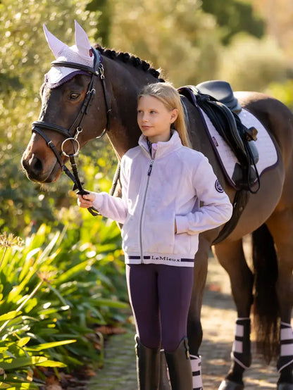 Girl with Horse Wearing LeMieux Young Rider Libby Fleece Jacket in Lilac - Equiflair Equestrian Apparel