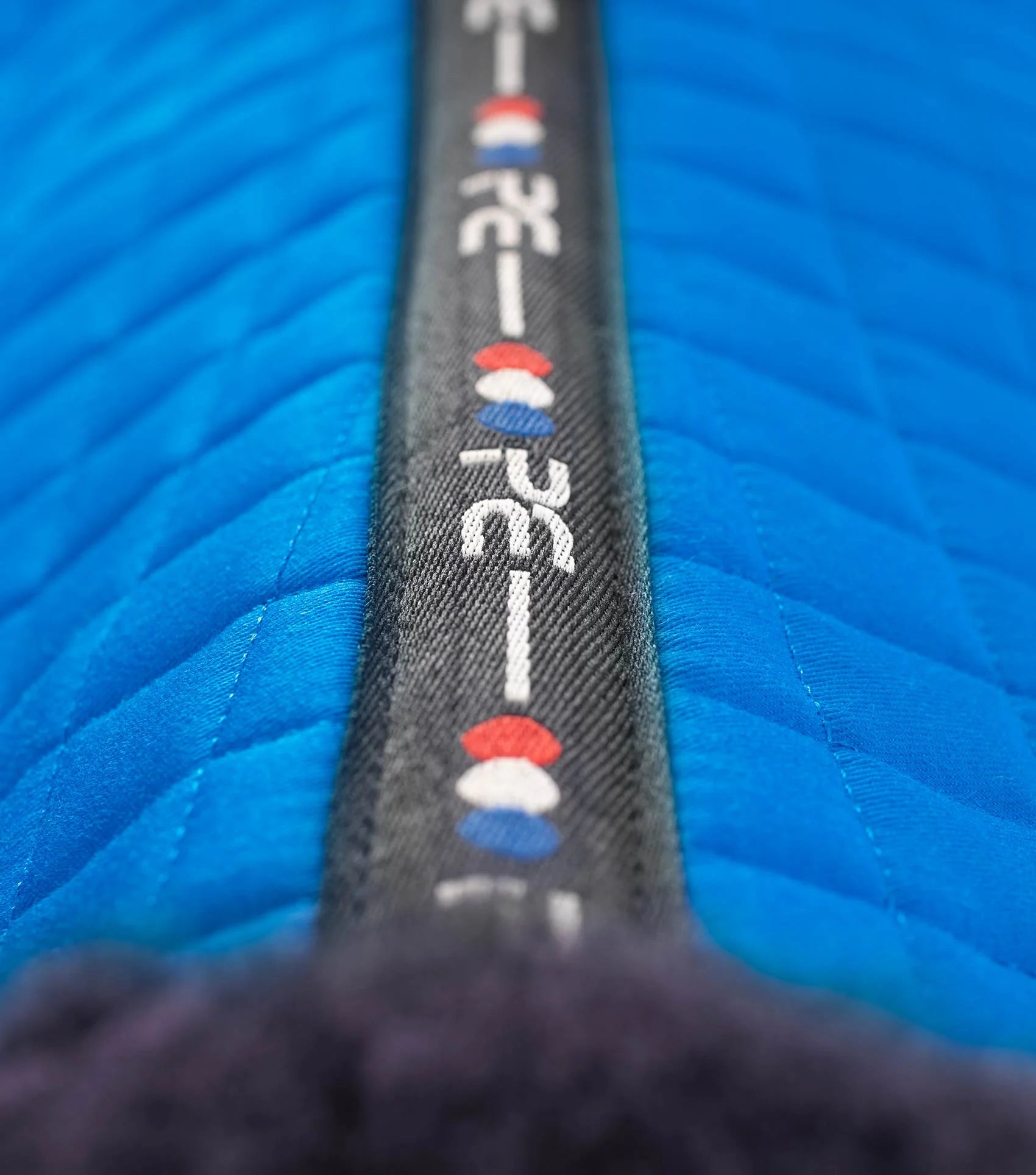 PREMIER EQUINE Merino Wool Dressage Saddle Pad - Royal Blue. Close-up showing wool and logo.