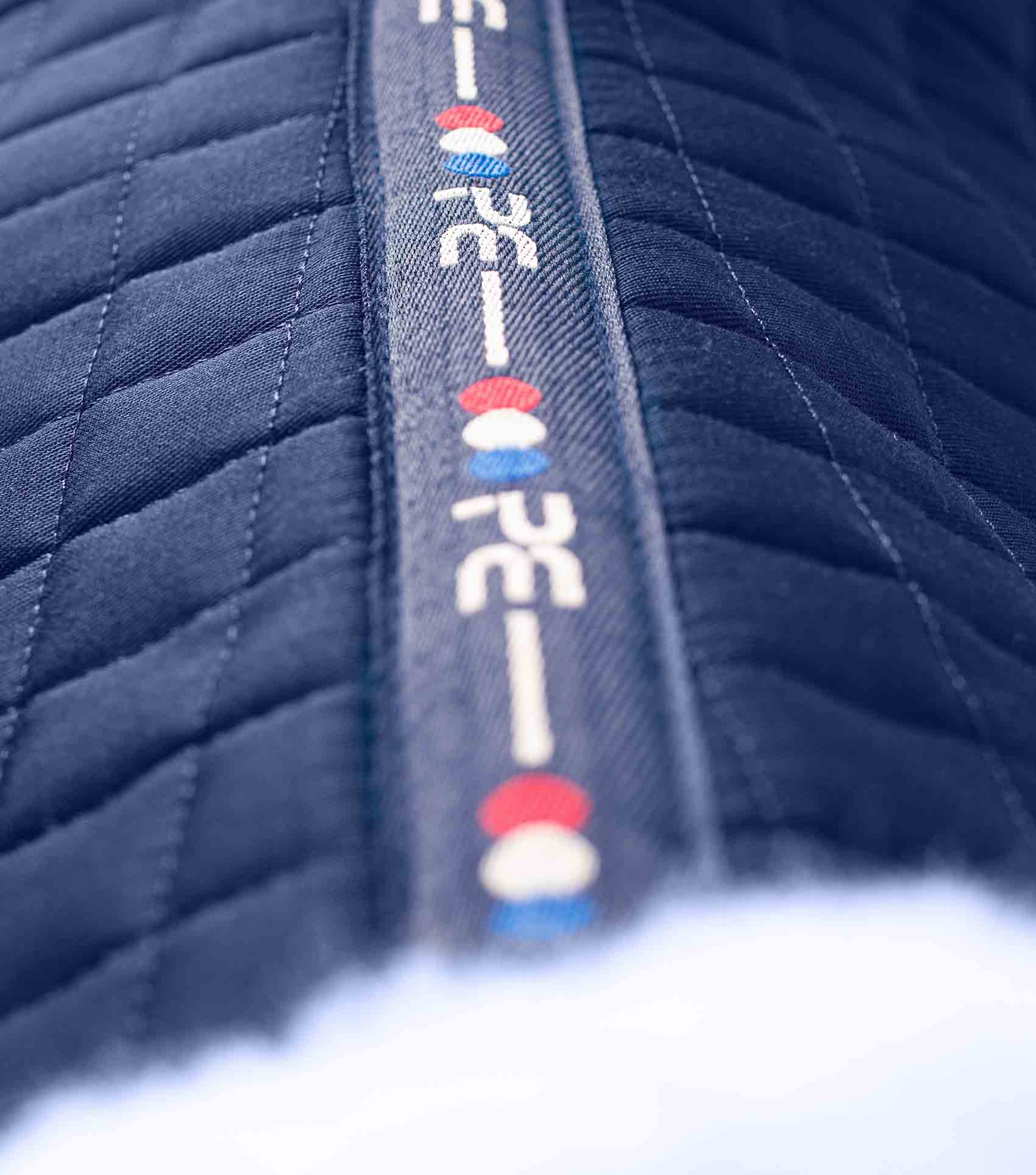 Premier Equine Merino Wool Navy Saddle Pad - GP/Jump Square. Close-up of quilted material and logo detail.
