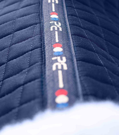 Premier Equine Merino Wool Navy Saddle Pad - GP/Jump Square. Close-up of quilted material and logo detail.