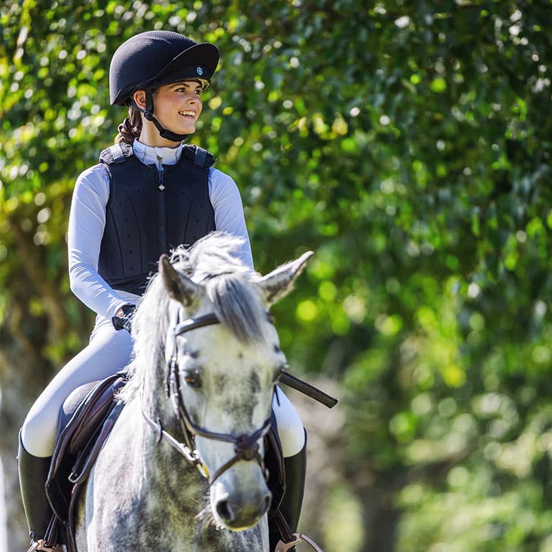 Equestrian Rider with CHARLES OWEN EQX Phoenix Skull Hat in Black/Silver - Safety Horse Riding Helmet