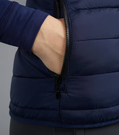 Premier Equine Navy Ladies Riding Gilet: Woman's hand in quilted equestrian vest pocket, close-up.