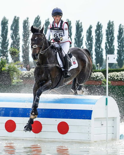 British Eventing: Horse and Rider Jumping Water Obstacle. Cross Country Equestrian Sport Competition. 