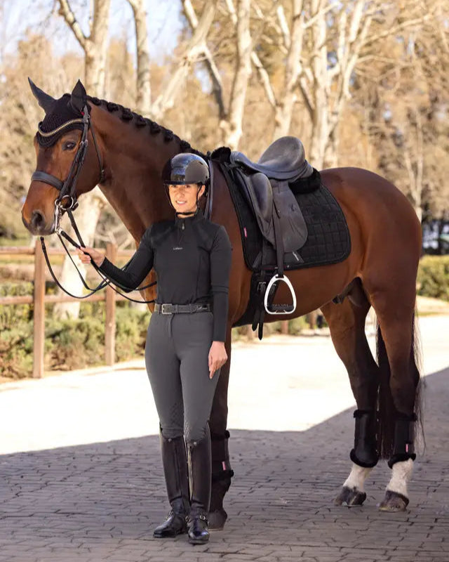 Equestrian fashion: Woman with Lemieux Diamante Dressage Saddle Pad & horse. Horse riding gear & equipment. Black saddle pad for dressage.