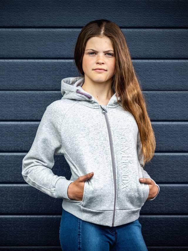 Young girl in LeMieux Young Rider Hollie Hoodie Grey Marl. Comfortable hooded sweatshirt for girls. Equiflair store product image.
