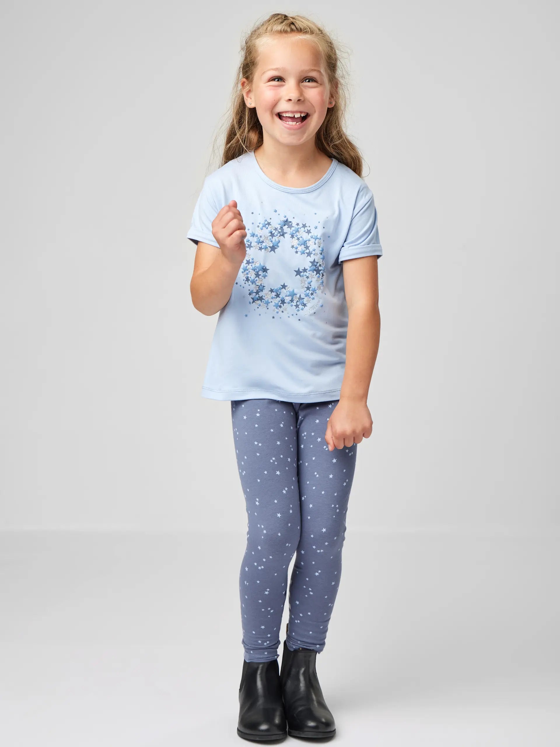 Girl in Lemieux star T-shirt and leggings with boots. Cute kids fashion, comfortable clothing, kids clothing, trendy apparel