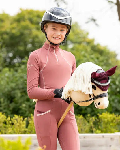 Girl in helmet with LeMieux Hobby Horse Popcorn. Equestrian toy for kids. Riding pretend play. Dressage hobby.