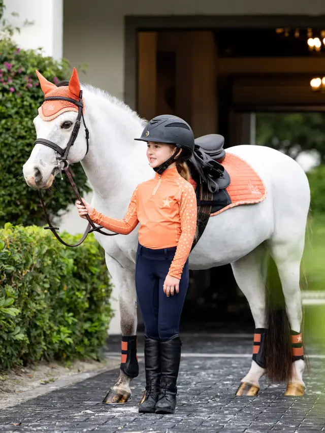 Young equestrian & white horse in matching Lemieux apricot riding gear from Equiflair. Child rider with horse in matching outfit