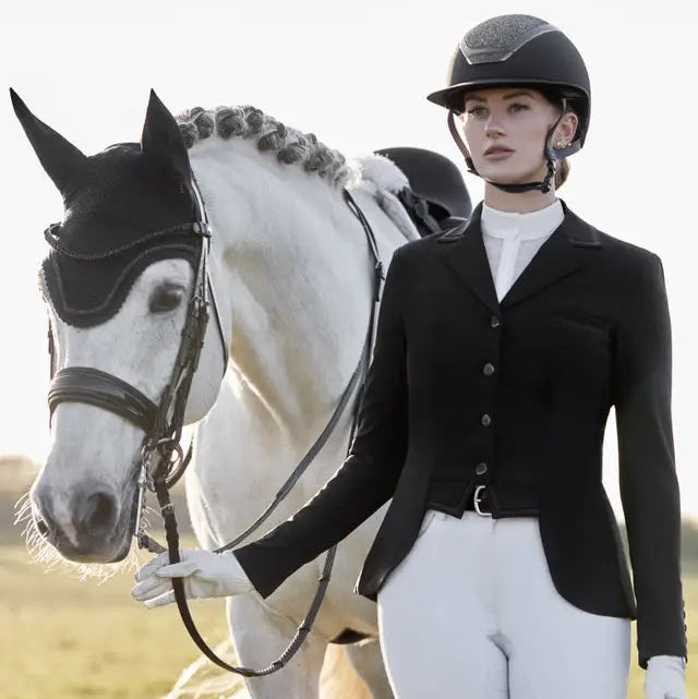 LeMieux Zoe Show Jacket Black: Equestrian style for dressage competition. Woman in black show jacket with white horse.
