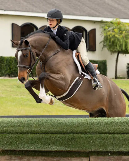 LeMieux Merino+ Hunter Saddle Pad in White: Horse and Rider Jumping over obstacle.