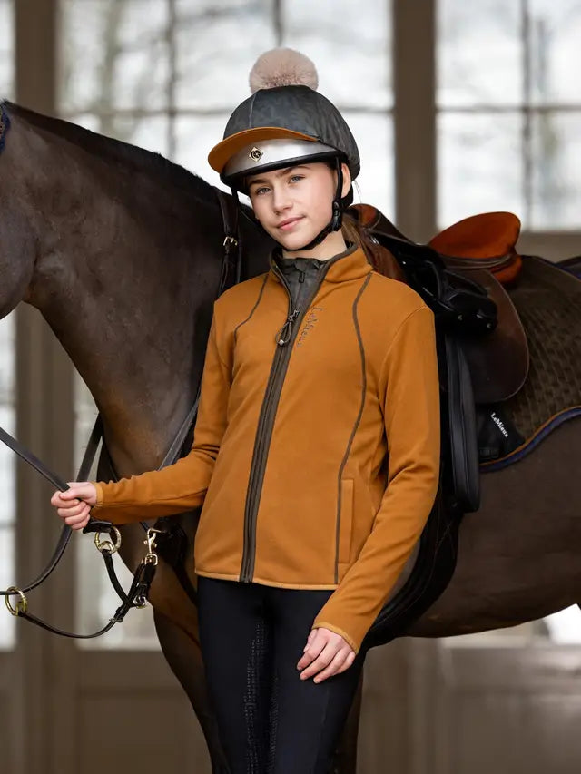 Young equestrian rider in Lemieux Felicity Fleece (Ginger) with horse. Warm, stylish riding fleece jacket for young riders.